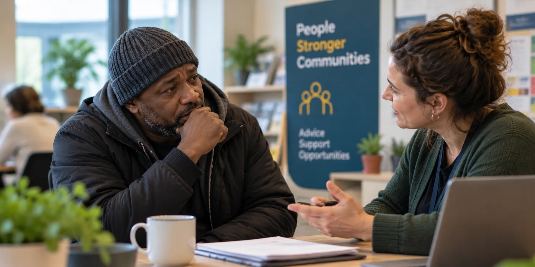 A charity adviser speaking with someone at a community support centre